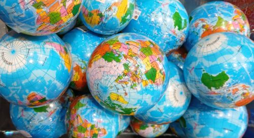 Viele kleine als Globus bedruckte Kugeln liegen auf einem Haufen.