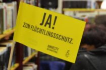 Kleine Amnesty-Fahne mit der Aufschrift "JA! zum Flüchtlingsschutz." in der Stadtbücherrei Stolberg