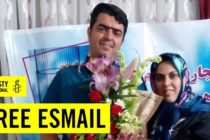 Foto von Esmail Abdi vor einem Plakat, darüber eingeblndet der Text "Free Esmail" und das Logo von Amnesty International