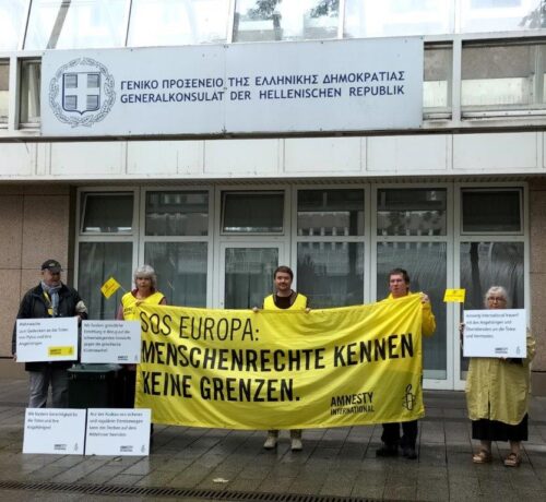 Amnesty Mahnwache for dem griechischen Generalkonsulat in Düsseldorf. Auf einem großen Banner steht "SOS Europa: Menschenrechte kennen keine Grenzen."