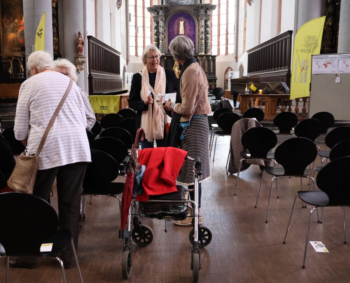 Menschen im Publikum tauschen sich in der Citykirche aus.