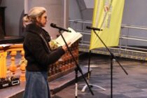 Eine Frau trägt im Altarraum der Citykirche einen Text aus einem Buch vor.