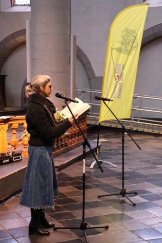 Eine Frau trägt im Altarraum der Citykirche einen Text aus einem Buch vor.