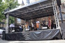 Auf einer Bühne vor dem historischen Aachener Rathaus tritt die Band Sin Fronteras auf.