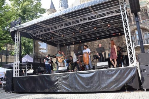 Auf einer Bühne vor dem historischen Aachener Rathaus tritt die Band Sin Fronteras auf.