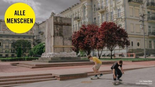 Foto von Fabian Ritter: Zwei junge Menschen sind in der Hof- und Parkanlage vor einem prächtigen Gebäude mit dem Skateboard unterwegs